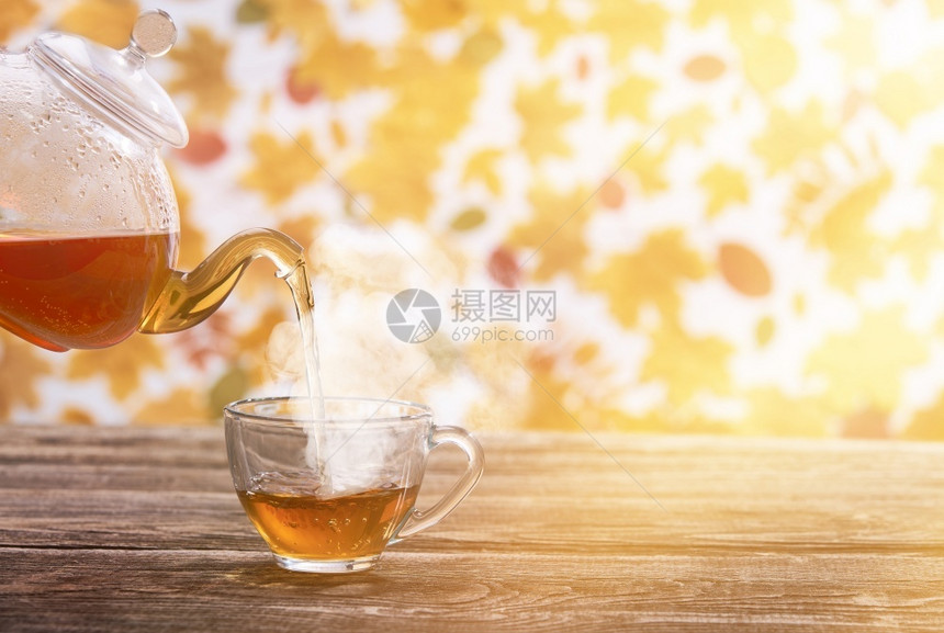 放松茶壶倒在生锈木制桌边的茶杯上秋天背景茶壶倒在杯中早餐心图片