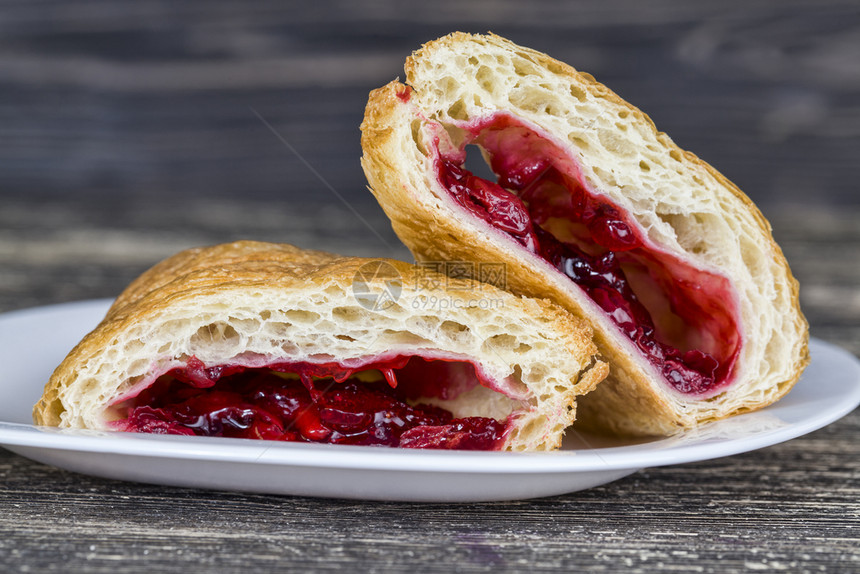 红色的水果中间切成面包美味的红樱桃果酱中间切成浆果馅饼包羊角面图片