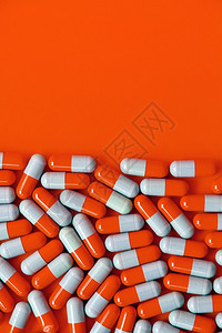 橙色背景上的胶囊药物图片