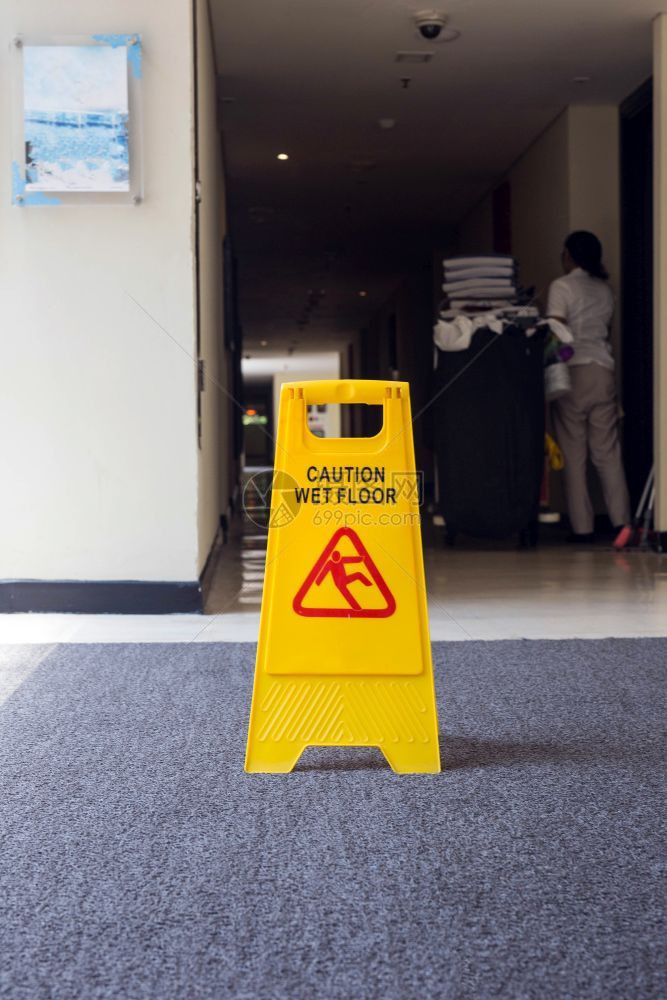 显示警告湿地板的标志黄色背景上的清洁剂显示警告湿地板的标志背景上清洁剂拖地器湿的图片