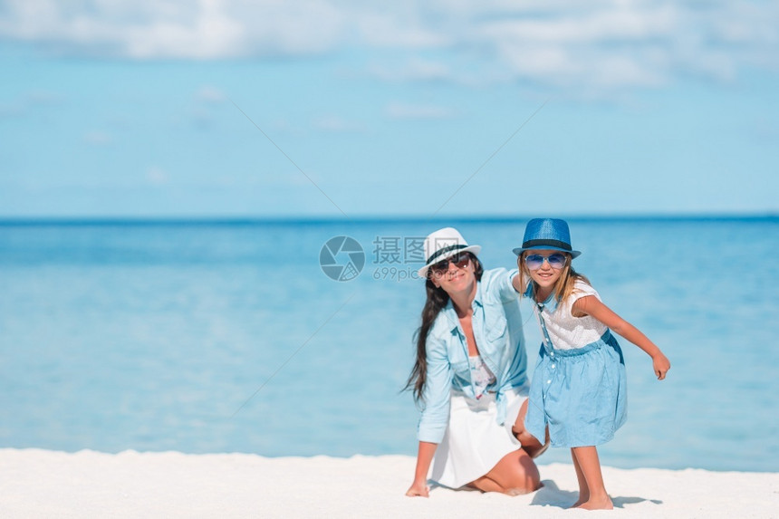 户外夏天小可爱女孩和年轻妈在热带海滩的妈还有女儿在海滩上图片