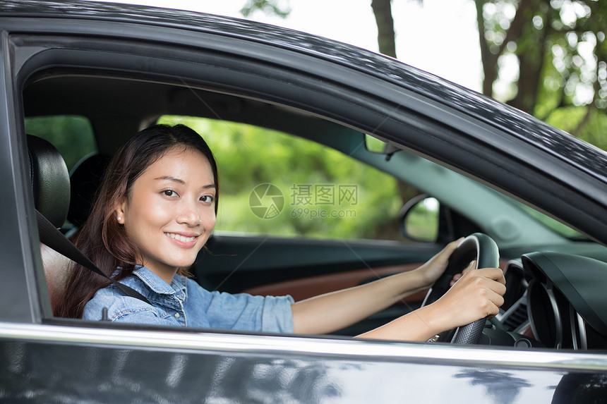 运输美丽的亚洲女在路上驾车旅行时微笑和愉快地开车为了人们图片