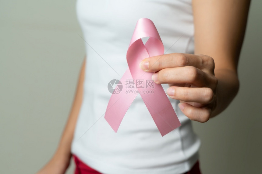 手拿粉色丝带的女性预防癌症概念图片