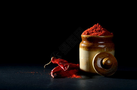 剪裁粘土锅中红辣椒粉和黑色底红辣椒粉调味料厨房图片