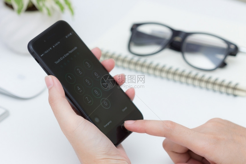 移动的桌子曼谷泰国2016年月23日关闭女人手扫描指解锁iphone7苹果公司开发的新7哑光黑色展示图片