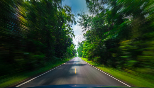 越野车从蓝色前看到沥青路和速度运动夏季在高速公路上模糊农村绿树林也模糊不清质地黄色的背景图片