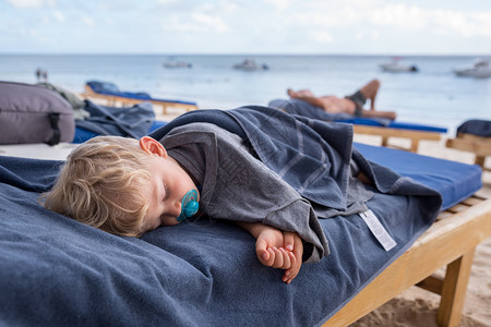 趴在沙滩椅子上熟睡的小女孩背景图片