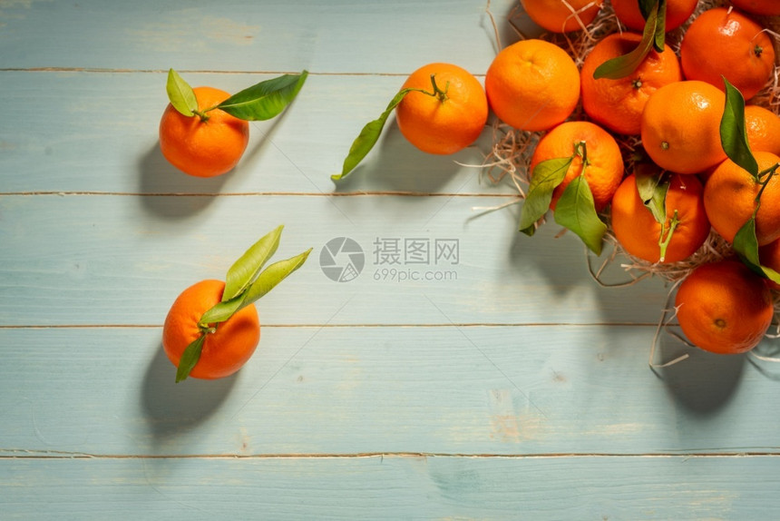 柑橘水果桌子蓝色木制板上的新鲜橘子图片