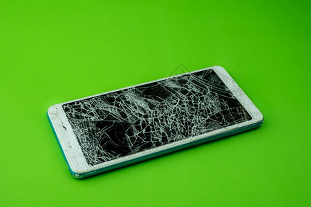 手机裂缝素材裂缝聪明的智能手机屏幕在绿色背景下破解劈开背景