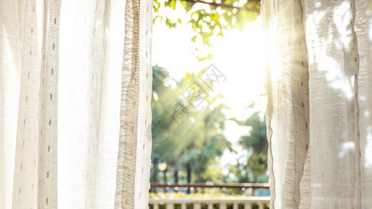 清晨太阳照亮门窗帘的白色简单丝绸图片