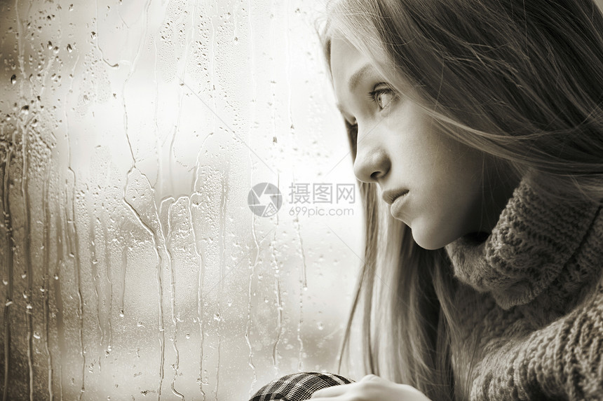 头发一位悲伤的青少年女黑白肖像她长的金发碧女郎在雨秋日坐窗户上季节仅有的图片