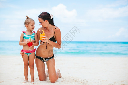 在海滩度假的母亲和小女儿可爱的孩和年轻母亲在热带白沙滩上的年轻妈可喜的小女孩和年轻母亲家庭情感年轻的妈妈高清图片素材