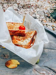 香脆的木制烹饪在户外餐桌上的三明治纸配着火腿和奶酪的烤面包意大利粉加火腿和奶酪图片