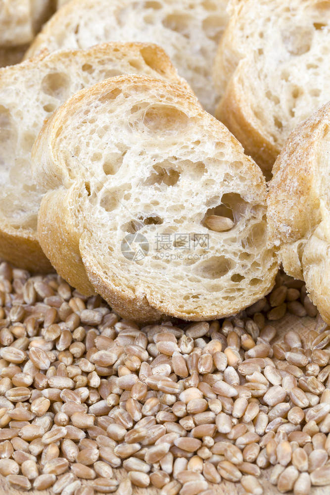 一顿饭用面粉制成的长袋面包切成碎块紧靠面粉中的原小麦谷物面粉正被烤包切开颜色片图片
