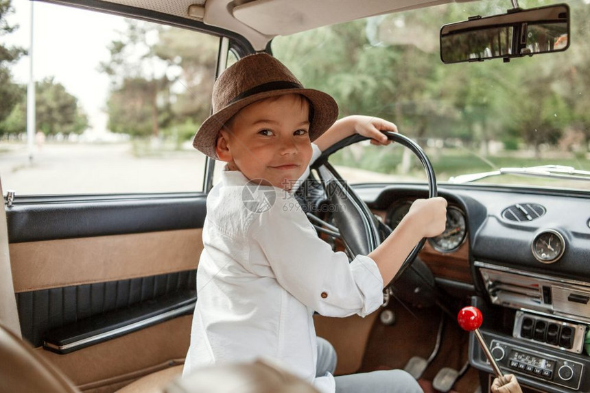 穿着古老衣服的白人小男孩坐在一辆旧车里老的复古快乐图片