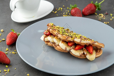 卡路里晚餐上面有香蕉草莓巧克力和活塞的松饼上面有香蕉草莓和巧克力酱图片