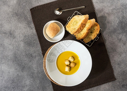 传统的热番茄汤和面包夹在盘大蒜包中放在石本面空白处食物图片