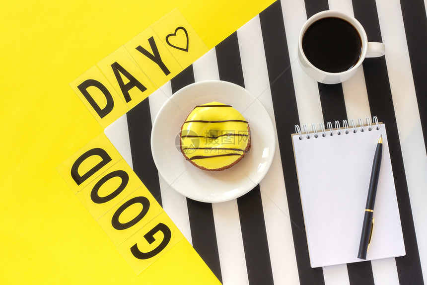 咖啡甜圈刻在时装黑纸巾上的注和黄底面墨白巾上贴在黄色背景最小风格的躺着现代时髦图片