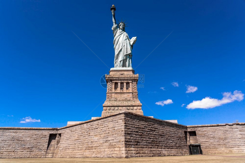 团结的蓝天下自由神像曼哈顿纽约市建筑和带有旅游观光概念建筑和移民脸图片