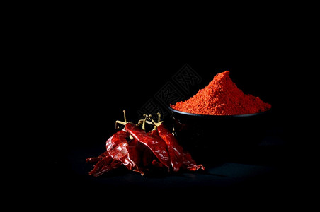 健康调味料辛辣的黑色碗中冷粉和红辣椒黑色底的干辣椒图片
