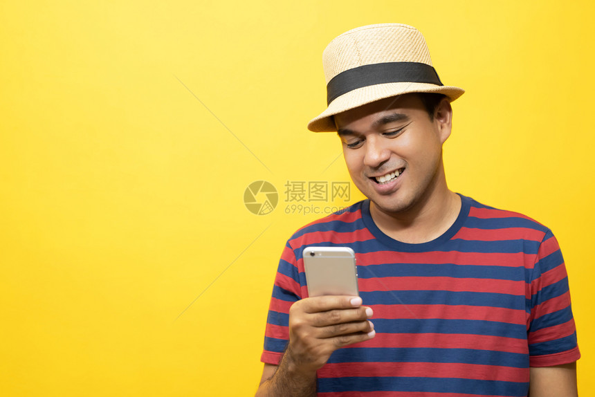 快乐的随意这个人站在黄墙上的色电话线在黄墙打手势图片