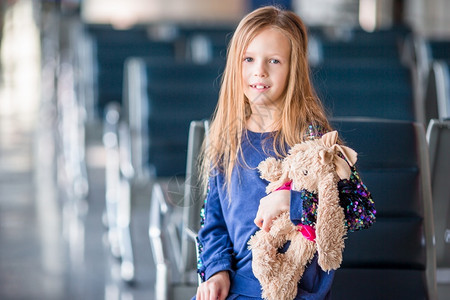 可爱的小女孩在机场带着她的行李登机前在场室内的可爱小女孩航班护照游客离开高清图片素材