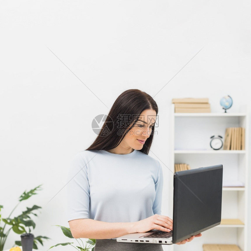 手妇女蓝打笔记本电脑键盘卧室忙碌的图片