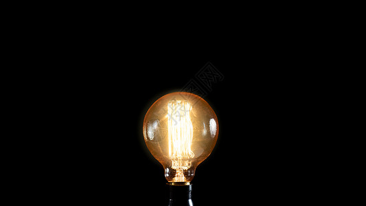 玻璃黑色背景上的老式爱迪生灯创意理念艺术丝白炽灯高清图片素材