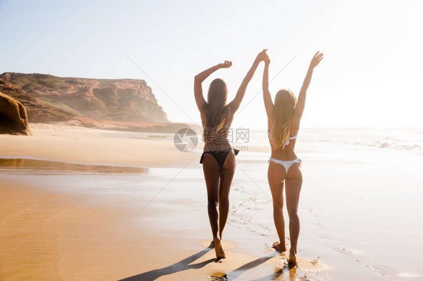 比基尼漂亮女孩在海滩上散步图片