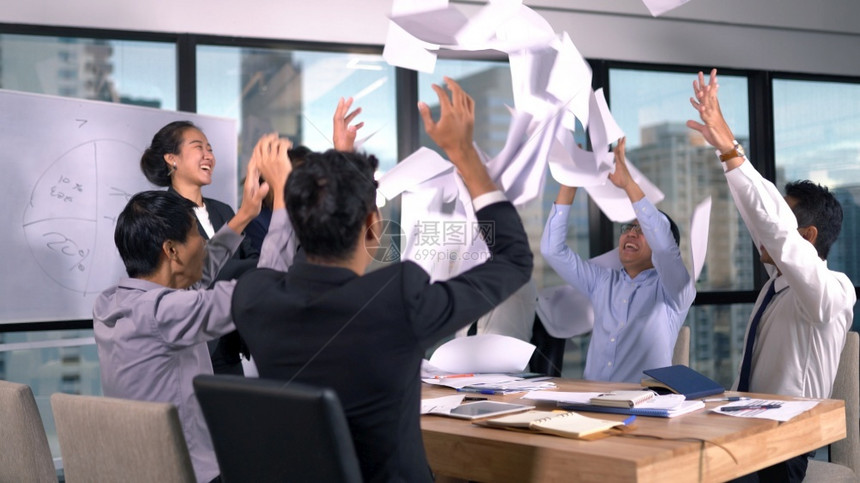亚洲业务团队在成功时扔纸职的文件图片