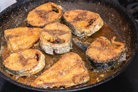 烧烤在黑炉子上煎锅里烧炸的新鲜鱼选择聚焦肉油炸红色的高清图片素材