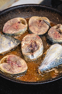 美食自制油炸在黑炉子上煎锅里烧炸的新鲜鱼选择聚焦红色的高清图片素材