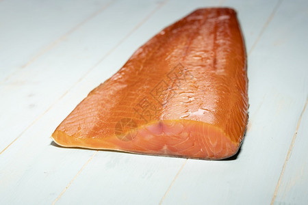挪威海洋一顿饭木制背景中熏的野生红鲑鱼高清图片
