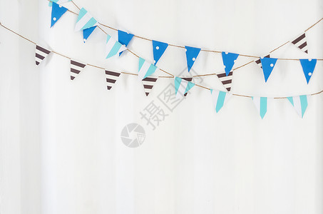 旗布沟挂在白色墙上绳索的三角旗布挂在白墙上庆典空的蓝色设计图片