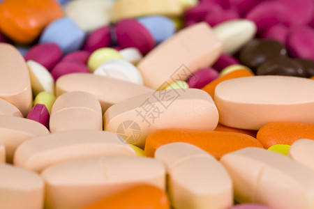 剂量黄色的化学存放多黄橙粉红药片为各种疾病提供混合药片和品的缝合多种颜色的黄橙粉红药片背景图片
