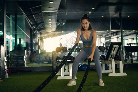 力量女子用战绳在健身房锻炼概念康在身房中进行重度锻炼努力练习图片