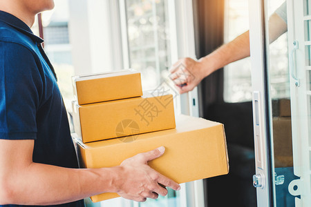 正面家亚洲人送货服务在客户口门前手拿着箱子提供亚洲人送货服务递图片