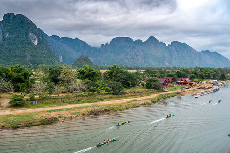 河边皮艇万老挝VangVieng的南宋江旅游船和山背景象背景图片