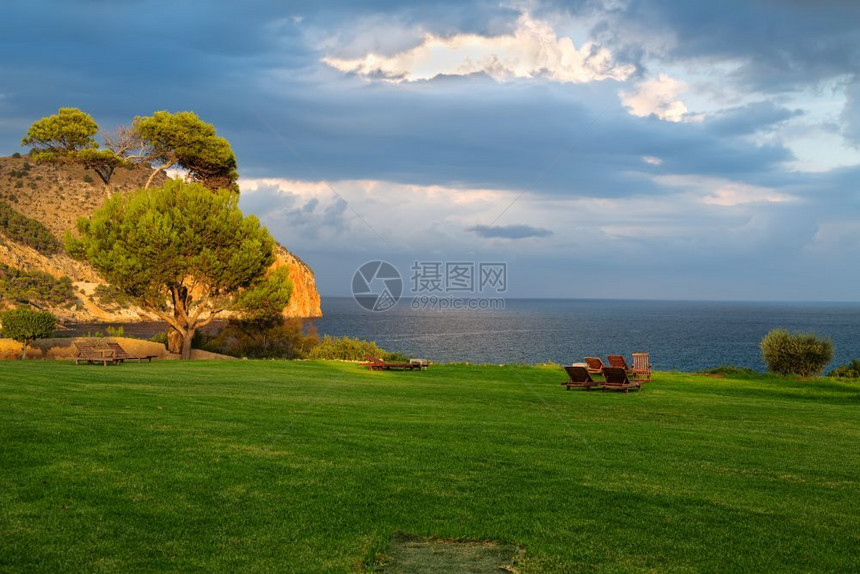 带有甲板椅子和海洋观的草坪采取自然放松图片