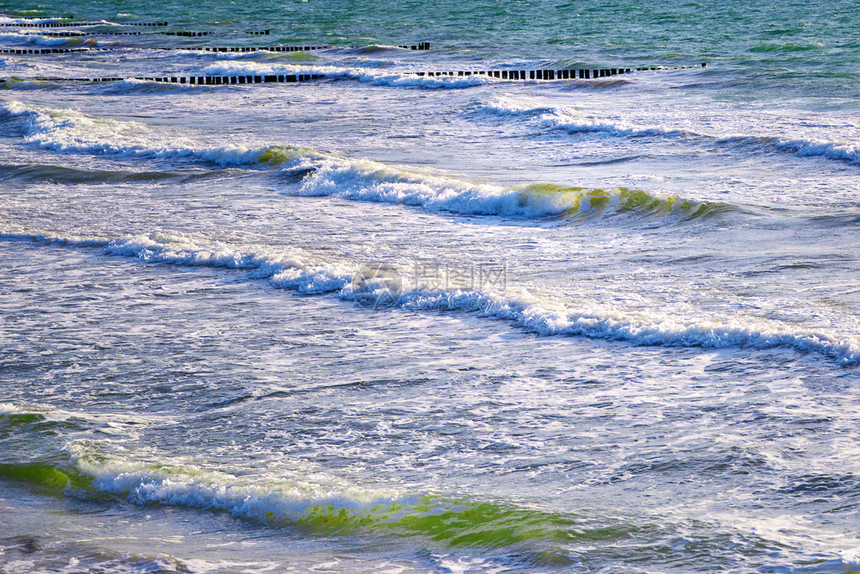 冲浪波向海滩滚动蓝色的浪水图片