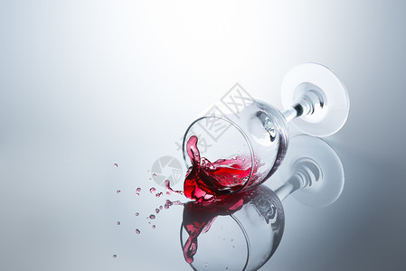 红酒从坠落的玻璃杯中溢出表面反射浪费高的溅图片