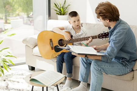 辅导男孩在家学习吉他男闲暇学生图片