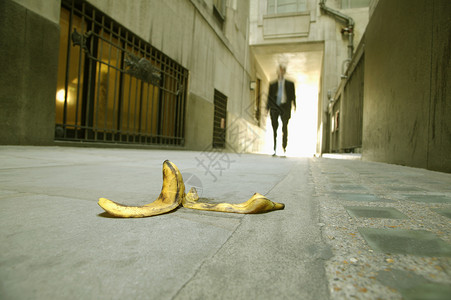 低的错误有风险商人向香蕉皮行走的低角度视图片