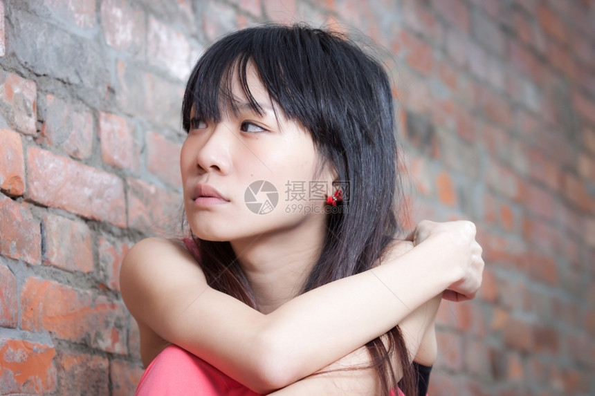 红色的坐在砖墙边年轻亚洲妇女感到沮丧和悲伤玻璃人类图片