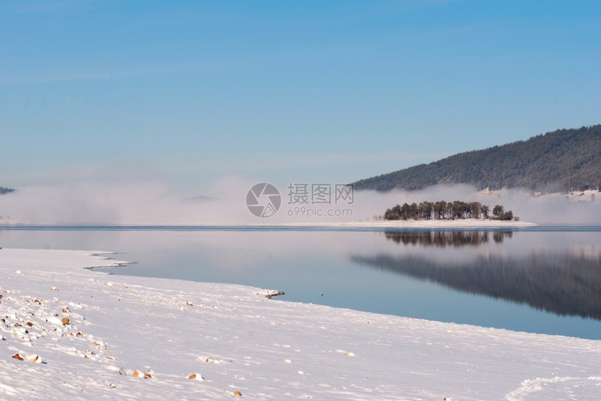 新的小路下雪湖岛和森林的冬季风景雾图片