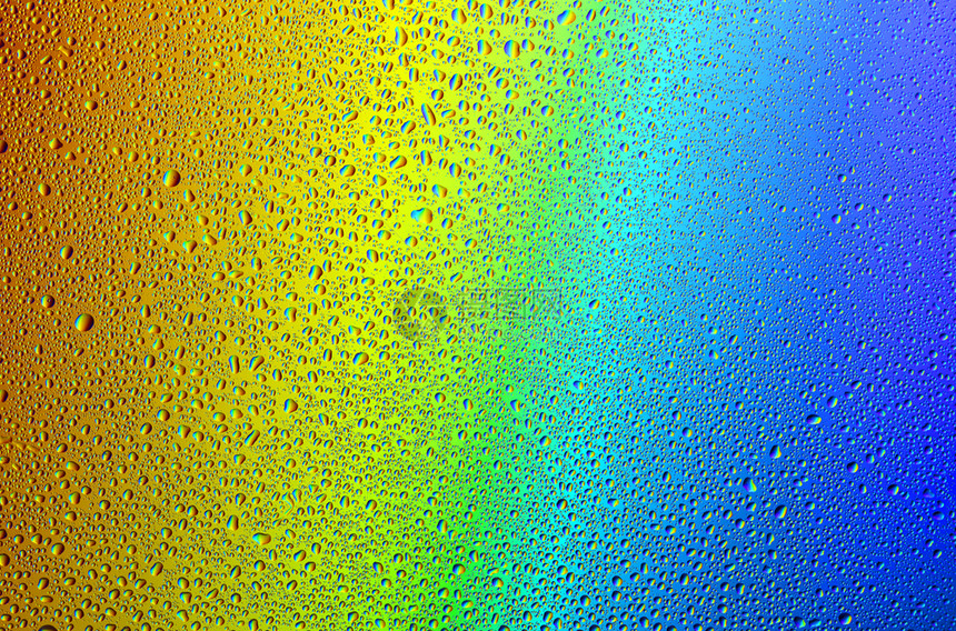 绿松石喷露彩虹背景下的水滴及其反射在彩虹背景中的水滴以及彩虹背景上的水滴图片