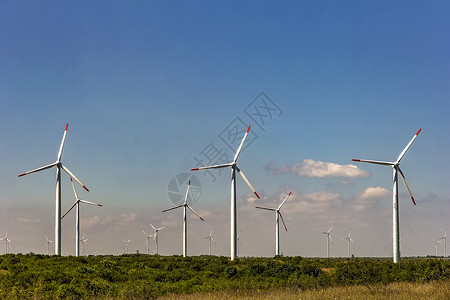 可再生技术蓝天空下风力涡轮机农场全球的螺旋桨高清图片素材