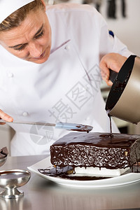 诱惑帽子盘厨房的糕点师装饰巧克力蛋糕图片