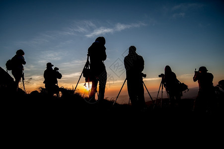 旅行户外摄影师在日出时拍摄地貌照片的轮廓工作图片