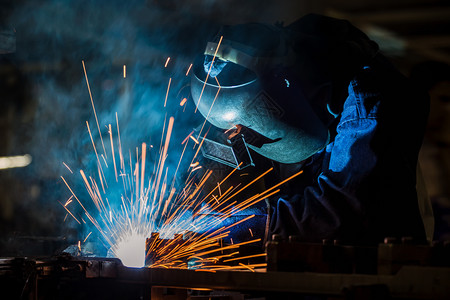 焊机制造业技能的工人在厂中焊接金属图片